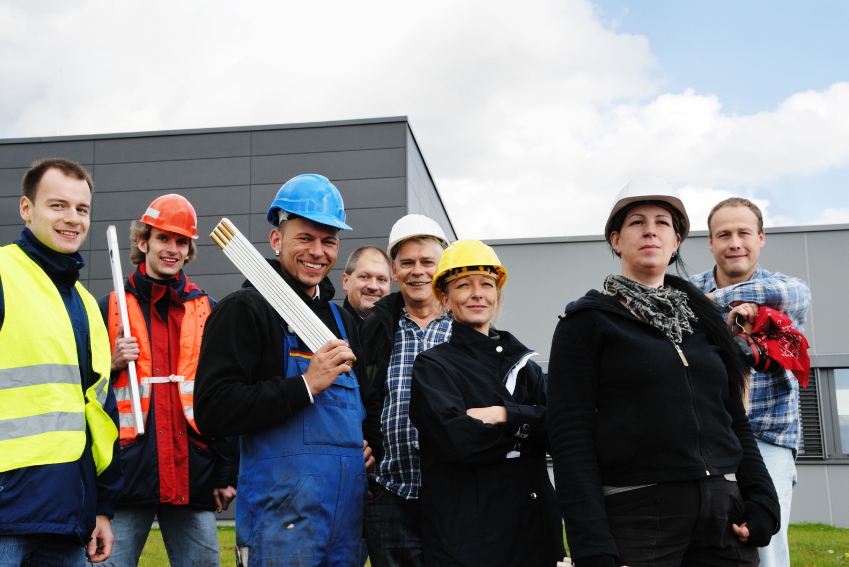 ein Team aus Mitarbeitern in Arbeitsschutzkleidung vor einem Gebäude